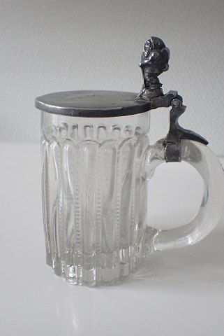 Nisse ølkrus i glas med låg af tin.